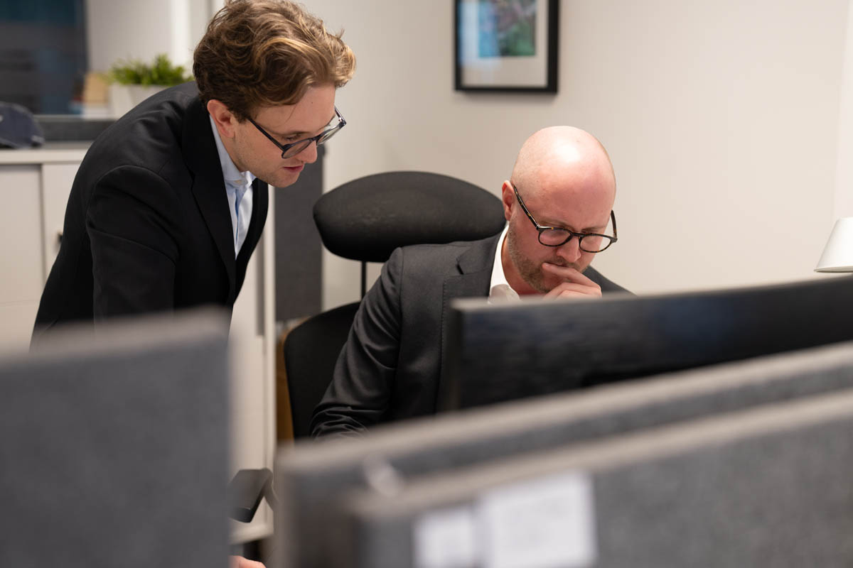 Personer går igenom information på dator i kontorsmiljö