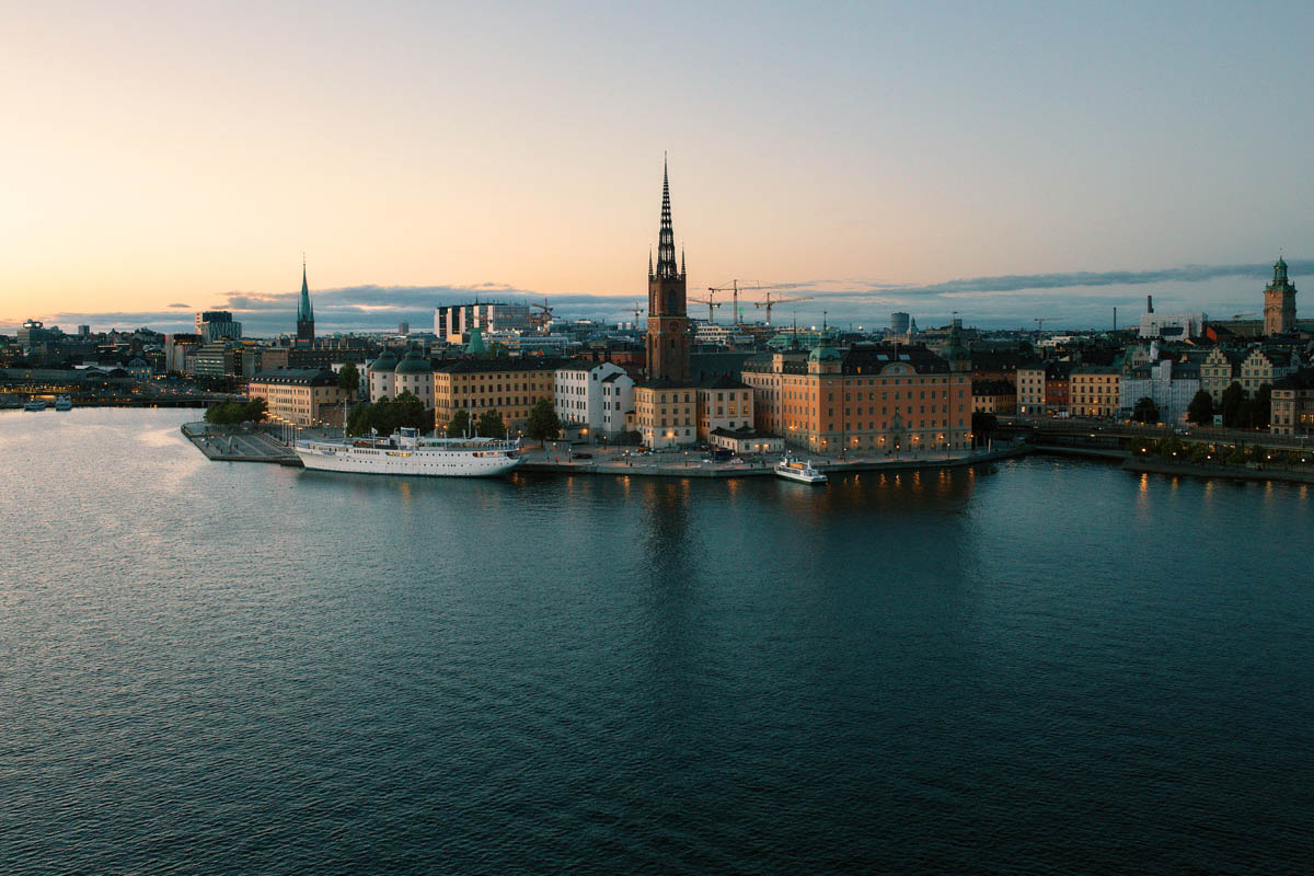 Stockholm med stadssiluett och kyrktorn vid vatten i skymningsljus