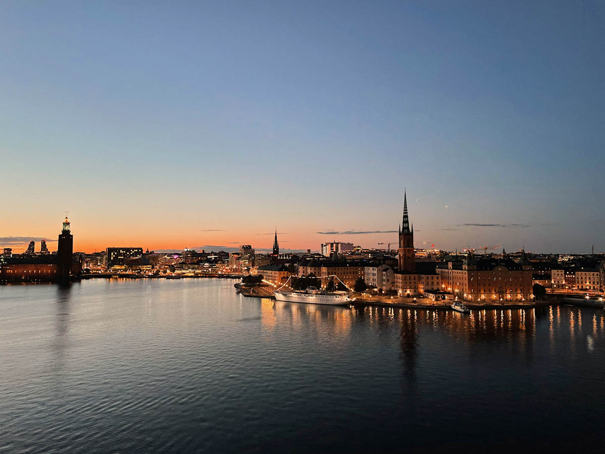 Stockholm stad med upplysta byggnader vid vatten i kvällstid